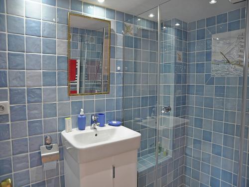 une salle de bain carrelée bleue avec un lavabo et une douche dans l'établissement Village House in Fayence with Castle Views, cleaning included, à Fayence