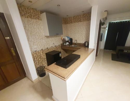 a kitchen with a counter and a sink in a room at A stylish cozy apartment close to Cairo airport. in Cairo