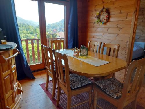 - une table et des chaises en bois dans une chambre avec fenêtre dans l'établissement Chalet with Garden in Lotharingen, cleaning included, à Saint-Maurice-sur-Moselle