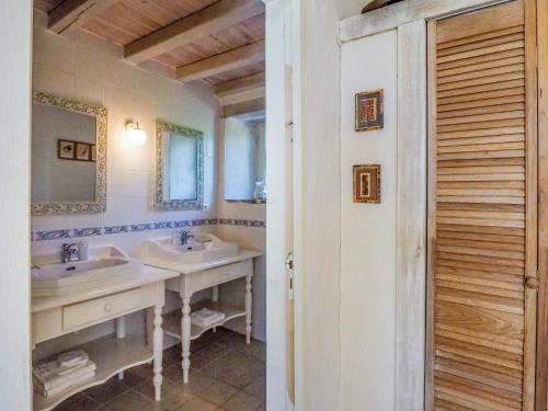 une salle de bain avec deux lavabos et un miroir dans l'établissement Holiday Home Saint-Laurent Pool & Garden, cleaning included, à Saint-Laurent-de-la-Salle