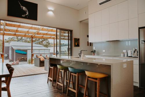 a kitchen with a large counter with stools at Serenity - Space for Everyone in St Helens