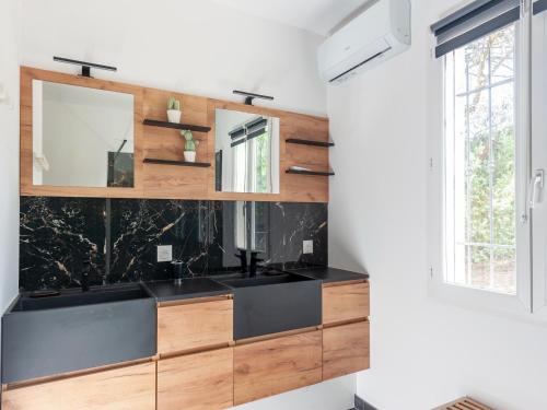 une salle de bain avec un lavabo noir et un miroir dans l'établissement Villa in Vidauban near Sainte Maxime Beach, cleaning included, à Vidauban