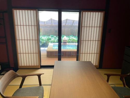 a table and two chairs in a room with a window at Kinnotake Saryo in Hakone