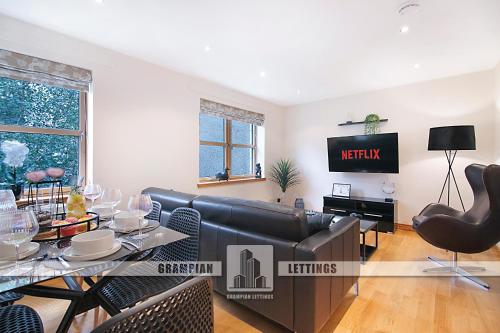 a living room with a couch and a table at Willowbank Road Apartments - Pets & Two Parkings in Aberdeen