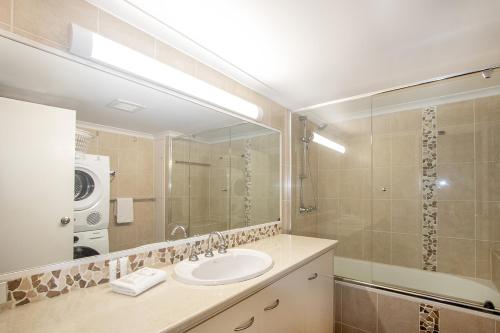 a bathroom with a sink and a large mirror at Sandcastles On Currumbin Beachfront, Gold Coast in Gold Coast