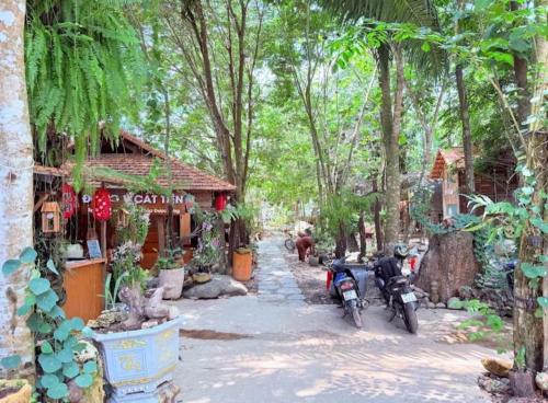 two motorcycles parked in front of a building with trees at Green Bamboo Lodge Resort in Cat Tien