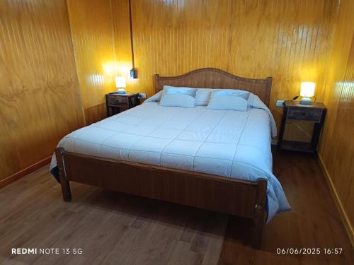 a bedroom with a large bed with two night stands at CABAÑAS REY-MAR in Castro