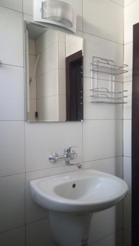 a bathroom with a white sink and a mirror at Adagio Sarafovo in Burgas