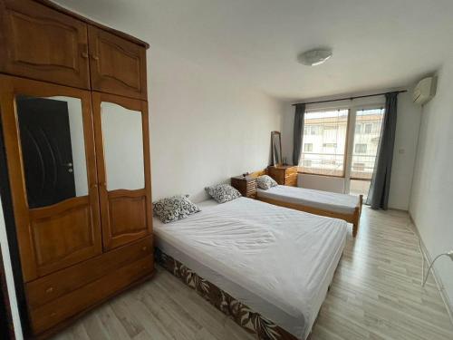a bedroom with two beds and a large cabinet at Adagio Sarafovo in Burgas