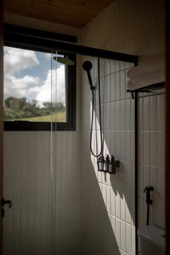 a shower in a bathroom with a window at TEKOÁ - Cabana Ipê - Barreiro, Araxá in Araxá