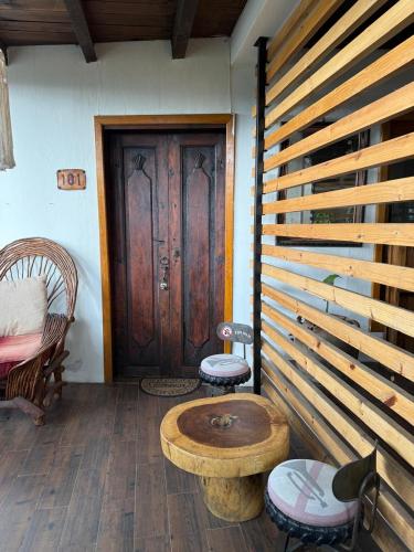 a room with a wooden door and a table and chairs at Departamentos San Francisco in San Cristóbal de Las Casas