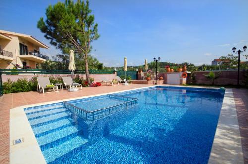a swimming pool with blue water in a yard at Villa Alimedon in Almirida