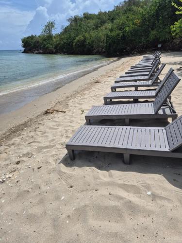 a row of benches sitting on a beach at Maranatha villa in Discovery Bay