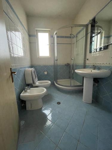 a bathroom with two toilets and a shower and a sink at B&B - Private rooms 3 in Tirana