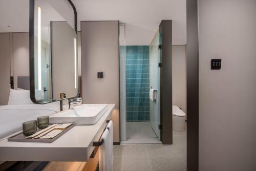 a bathroom with a sink and a shower at Holiday Inn Express Qingdao City Balcony by IHG in Qingdao