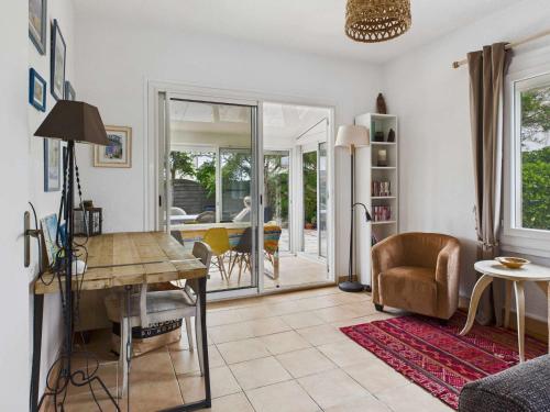un salon avec une table et une chaise dans l'établissement Maison plain-pied 3 chambres, terrasse et climatisation, 8 pers - FR-1-326-860, à Marseillan