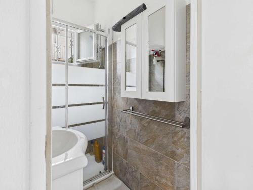 une salle de bain blanche avec des toilettes et un lavabo dans l'établissement Maison plain-pied 3 chambres, terrasse et climatisation, 8 pers - FR-1-326-860, à Marseillan