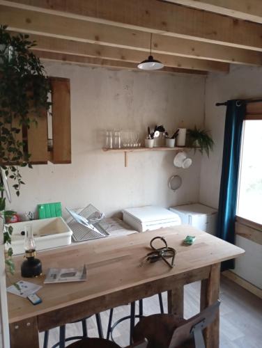 - une cuisine avec une table en bois dans une chambre dans l'établissement cabane au bord de l'eau pas de carpe dans l'étang pas d'électricité !, 