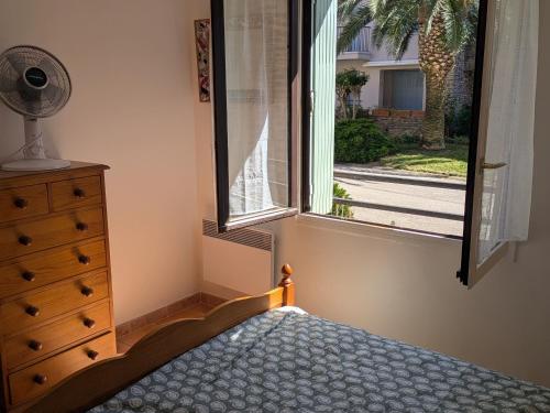- une chambre avec un lit, une fenêtre et une commode dans l'établissement Appartement T2 Neuf à Collioure avec Terrasse, Parking, Tennis et Animaux Acceptés - FR-1-309-442, à Collioure