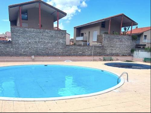 une grande piscine devant une maison dans l'établissement Appartement T2 Neuf à Collioure avec Terrasse, Parking, Tennis et Animaux Acceptés - FR-1-309-442, à Collioure