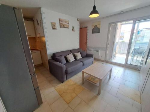 un salon avec un canapé et une table dans l'établissement Appartement 2 pièces avec loggia aménagée à Marseillan-Plage - FR-1-326-863, à Marseillan