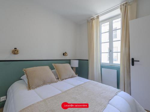 une chambre avec un grand lit avec une fenêtre dans l'établissement Appartement T2 Moderne, Proche Marché, Capacité 3 Pers, Wifi - FR-1-535-68, à La Rochelle