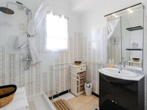une salle de bain blanche avec un lavabo et un miroir dans l'établissement Appartement T3 à 2 min de la mer, 4 personnes, balcon vue mer - FR-1-409-283, à Narbonne