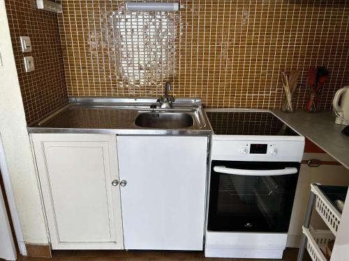 une cuisine avec un évier et une cuisinière dans l'établissement Appartement Port Camargue - 4 Pers, Clim, Parking - FR-1-250-312, au Grau-du-Roi