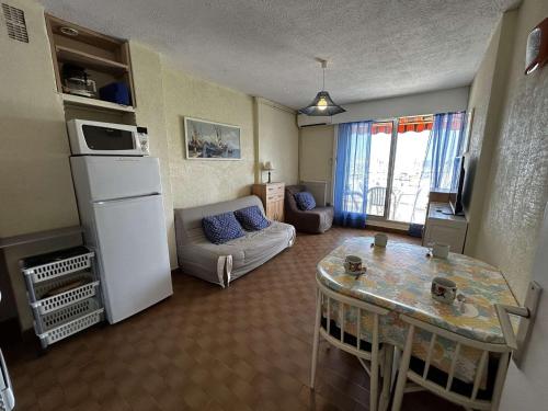 - un salon avec un réfrigérateur blanc et une table dans l'établissement Appartement Port Camargue - 4 Pers, Clim, Parking - FR-1-250-312, au Grau-du-Roi