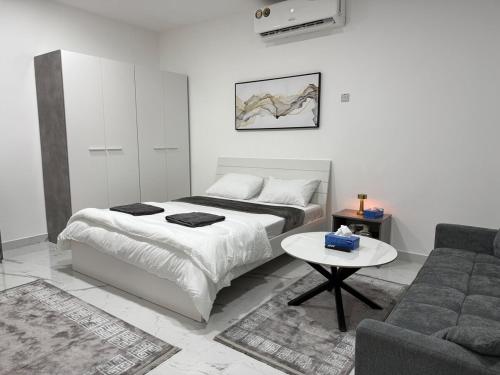 a bedroom with a bed and a couch and a table at Brand new -Stylish Studio Near to Yas & Airport in Abu Dhabi