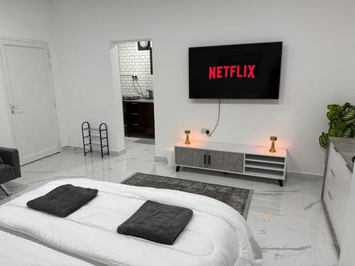 a bedroom with a bed and a tv on the wall at Brand new -Stylish Studio Near to Yas & Airport in Abu Dhabi