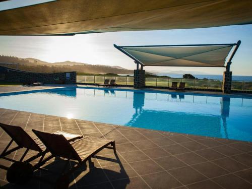a swimming pool with two chairs and a canopy at White Sands Estate in Falmouth