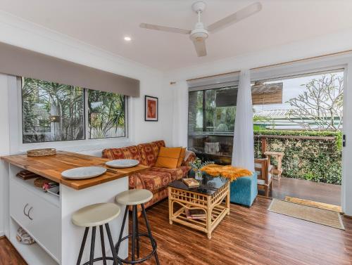 a kitchen and living room with a couch and a table at Caba Beach Condo Highly rated, roomy 2-bedroom cabin, walk to the beach! Private & Quiet in Cabarita Beach