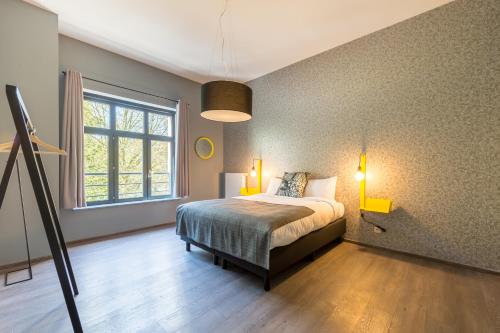a bedroom with a bed and a large window at Smartflats Design - Berlaymont in Brussels