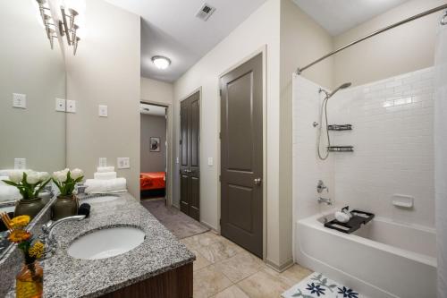 Un baño con lavabo, bañera y ducha. en Truist Luxe Haven near Battery, en Atlanta