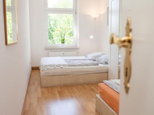 een slaapkamer met 2 bedden en een raam bij Ferienwohnung Leipzig Ost in Leipzig