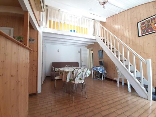 une salle à manger avec une table et un escalier dans l'établissement Maison moderne entre forêt et océan, avec jardin et terrasse. - FR-1-239-425, à Seignosse