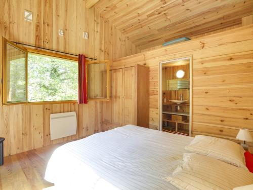 une chambre avec un lit dans une cabane en bois dans l'établissement Belle villa en bois 6 personnes avec terrasse et Wi-Fi à Biscarrosse - FR-1-521-71, à Biscarrosse