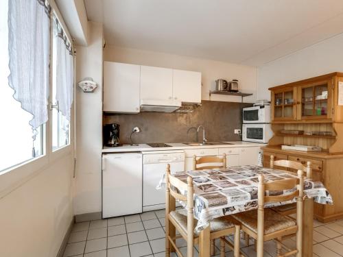 une cuisine avec des armoires blanches et une table et des chaises dans l'établissement Appartement T2 cabine à Biscarrosse-Plage, proche océan, 4 pers. - FR-1-521-84, à Biscarrosse-Plage