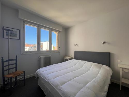une chambre avec un grand lit blanc et une fenêtre dans l'établissement Appartement lumineux, proche plage, balcon, parking, WiFi - FR-1-239-962, à Saint-Jean-de-Luz