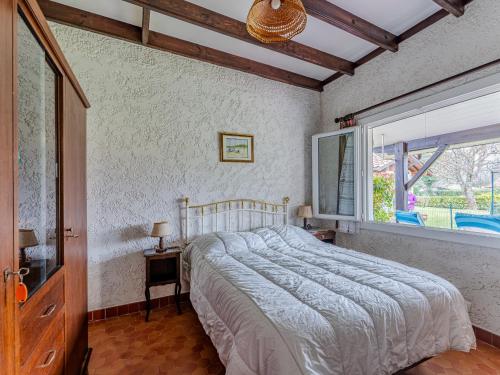 une chambre avec un grand lit et une fenêtre dans l'établissement Maison à Sanguinet pour 3 pers, 200m du lac, terrasse et jardin - FR-1-521-250, à Sanguinet