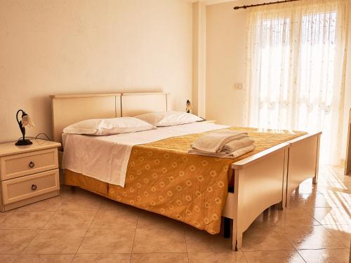 ein Schlafzimmer mit einem großen Bett, einer Kommode und einem Fenster in der Unterkunft Goritto in Dorgali