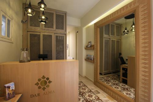 a salon with a mirror and a door to a room at Dar Alma in Soûr
