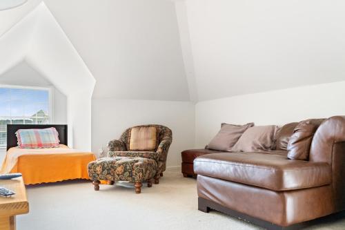 a living room with a couch and a chair at Spacious 4BR Home Pools Bikes Balcony in Berlin