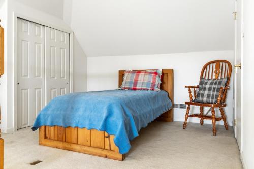 a bedroom with a wooden bed and a chair at Spacious 4BR Home Pools Bikes Balcony in Berlin