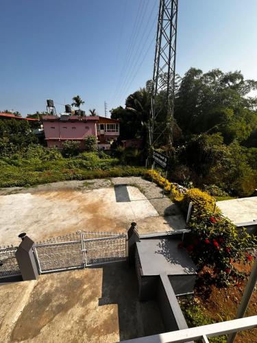 a park with a bench and flowers and a tower at The river homestay in Kushālnagar