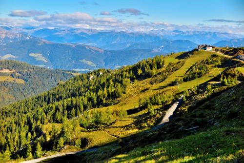 a view of a mountain with a house on a hill at Apartments Bergblick in Sonnenalpe Nassfeld