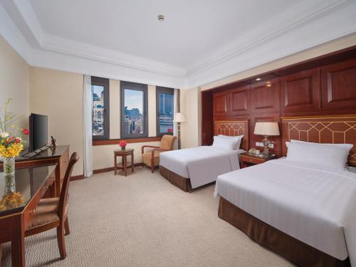 a hotel room with two beds and a desk at Shanghai Park Hotel - Hudec Excellent Historical Building - Priority Access for Classic Butterfly Cookies Without queuing to guests in Shanghai
