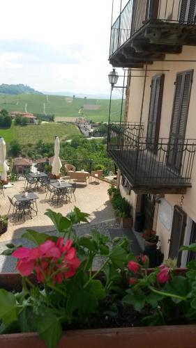 a view of a building with tables and chairs and flowers at Il Borgo B&B in Castellinaldo