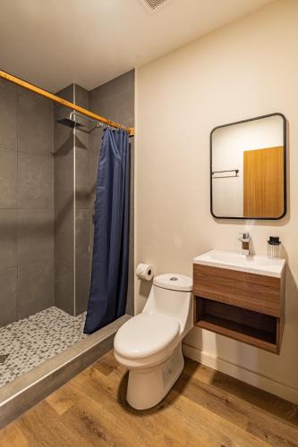 a bathroom with a toilet and a sink and a shower at Lora Loca Inn in El Zonte
